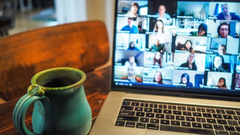 grüner Krug vor einer laufenden Videokonferenz mit vielen Kacheln