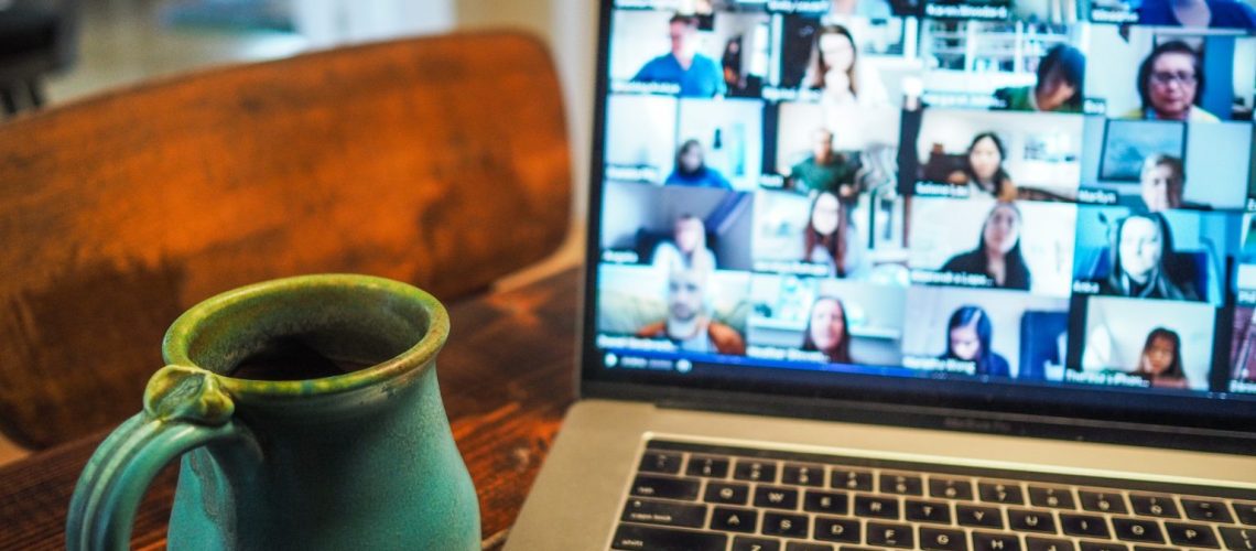 grüner Krug vor einer laufenden Videokonferenz mit vielen Kacheln